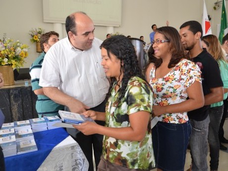 Docentes e Equipe entregam certificados, foto e livros para os participantes.