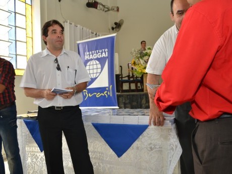 Docentes e Equipe entregam certificados, foto e livros para os participantes.