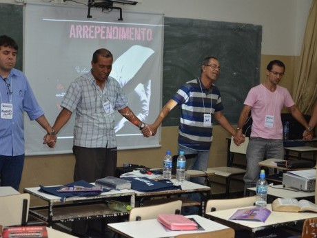 Participantes em oração, clamando a Deus, durante a última aula do sábado à noite.
