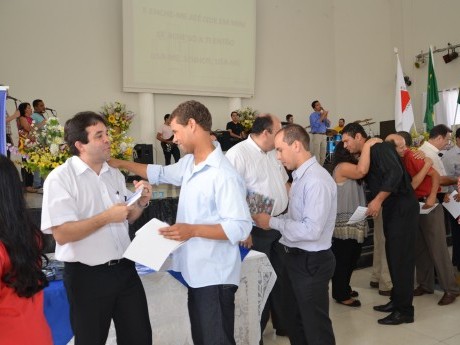 Docentes e Equipe entregam certificados, foto e livros para os participantes.