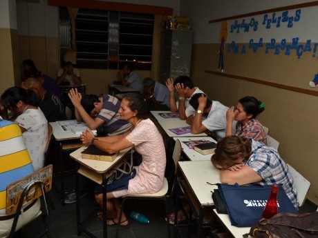 Participantes em oração, clamando a Deus, durante a última aula do sábado à noite.