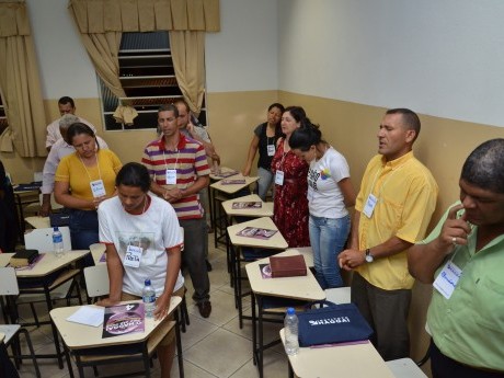Participantes em oração, clamando a Deus, durante a última aula do sábado à noite.