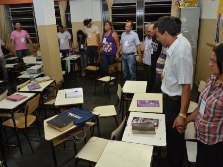 Participantes em oração, clamando a Deus, durante a última aula do sábado à noite.