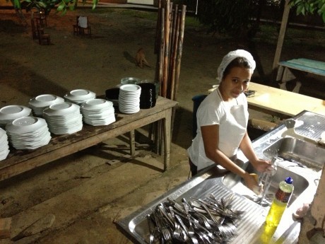 Lavando louça depois do jantar em local muito precário.
