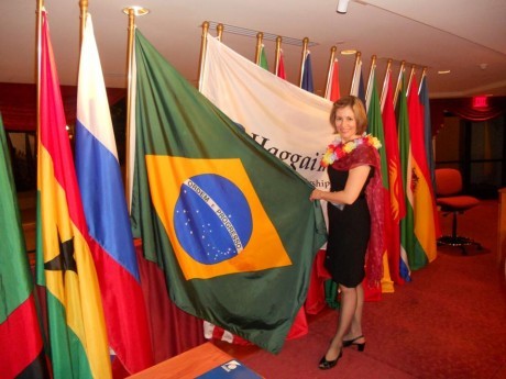 Junto às bandeiras das nações, com destaque à bandeira brasileira