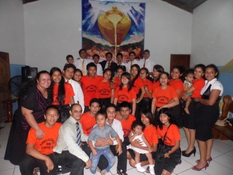 Igreja em Pucalpa: Esposa em pé (vestido escuro), filhos ao lado (camisa branda e cinza, agachados)